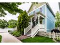 Two-story home featuring a quaint porch, a neatly landscaped yard, and light blue and green exterior at 2017 Rhettsbury St, Carmel, IN 46032