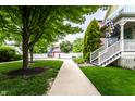Sidewalk view of homes with well-manicured lawns and trees that shows an appealing community setting at 2017 Rhettsbury St, Carmel, IN 46032