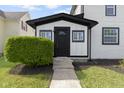 Welcoming entrance with a black front door and manicured landscaping at 2111 S A St, Elwood, IN 46036