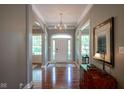 Welcoming foyer features gleaming hardwood floors, elegant chandelier, and neutral paint at 2223 Shaftesbury Rd, Carmel, IN 46032