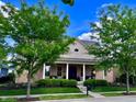 Charming home with manicured landscaping and a welcoming front porch with white pillars at 2223 Shaftesbury Rd, Carmel, IN 46032