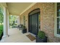 Inviting covered front porch with columns, seating, and stylish brickwork at 2223 Shaftesbury Rd, Carmel, IN 46032
