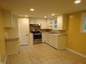Well-lit kitchen featuring stainless steel appliances, white cabinets, and tile floors at 229 Arnold St, Morgantown, IN 46160