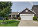 Inviting single-story home with manicured lawn, flowering bushes, and a two-car garage at 2432 Bridlewood Dr, Franklin, IN 46131