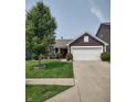 Inviting single-story home with manicured lawn, flowering bushes, and a two-car garage at 2432 Bridlewood Dr, Franklin, IN 46131