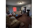 View of a living room with blue walls, hardwood floors, two couches, and a coffee table with clutter at 2627 Lincoln St, Anderson, IN 46016