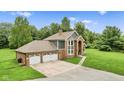 Attractive brick and gray home with three-car garage, stone driveway, and well-kept lawn at 2871 Mullinix Rd, Greenwood, IN 46143