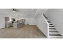 Bright, open-concept living room and kitchen with hardwood floors and staircase at 2903 Winthrop Ave, Indianapolis, IN 46205