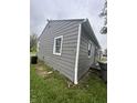 View of home's durable gray siding and functional rain guttering near the green lawn at 3202 N Emerson Ave, Indianapolis, IN 46218