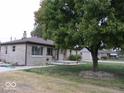 Landscaped front yard with mature tree providing shade and curb appeal to the home at 3456 S Sadlier S Dr, Indianapolis, IN 46239