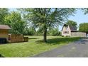 Expansive backyard featuring a wooden deck and a charming barn-style shed at 4124 Five Points Rd, Indianapolis, IN 46239