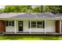Inviting covered front porch with white columns and black trim, with a traditional front door at 4275 Springwood Trl, Indianapolis, IN 46228