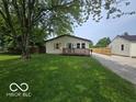 Single-story house featuring a front porch, green lawn, and a gravel driveway at 450 N Fenton Ave, Indianapolis, IN 46219