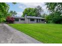 Attractive home exterior with a lush front yard and stone details at 4853 E 65Th St, Indianapolis, IN 46220