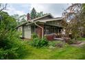 This lovely craftsman home features a brick foundation, green siding, and mature landscaping at 5133 E Michigan St, Indianapolis, IN 46219