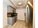 Galley kitchen with stainless steel appliances and grey cabinetry at 5153 Brendonshire Ct, Indianapolis, IN 46226