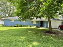 Charming blue brick ranch home featuring an attached garage and well-manicured front lawn at 7103 E Wiser Ave, Camby, IN 46113