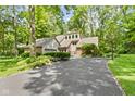 Attractive home with a long driveway, brick details, and verdant surroundings at 7426 Shadow Wood Dr, Indianapolis, IN 46254