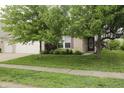 Inviting brick home featuring a lush green lawn and a welcoming entrance under the shade of mature trees at 10112 Split Rock Way, Brownsburg, IN 46112