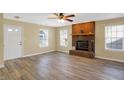 Bright living room featuring a brick fireplace, wood flooring, and ample natural light at 1024 Rotherham Ln, Beech Grove, IN 46107