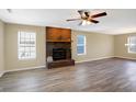 Spacious living room with a brick fireplace, ceiling fan, and hardwood floors filled with natural light at 1024 Rotherham Ln, Beech Grove, IN 46107