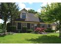Well-maintained home with lush lawn, mature trees, brick facade, attached garage and red Japanese maple at 1065 Lakewood South Dr, Brownsburg, IN 46112