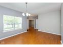 Bright living room boasts wood floors, neutral walls, and ample natural light from a large window at 10725 Tedder Lake Dr, Indianapolis, IN 46239