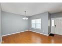 Bright living room boasts wood floors, neutral walls, modern light fixture, and ample natural light at 10725 Tedder Lake Dr, Indianapolis, IN 46239