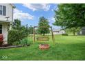 Landscaped backyard featuring a cozy swing set and a brick fire pit for outdoor enjoyment at 11198 N 650 W, Fountaintown, IN 46130