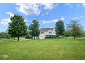 A well-maintained two-story home surrounded by green lawn and mature trees on a sunny day at 11198 N 650 W, Fountaintown, IN 46130