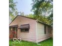 Side view of a one-story home surrounded by mature trees and a well-maintained lawn at 1143 Sharon Ave, Indianapolis, IN 46222