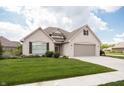 Charming single-Gathering home with a brick exterior, lush green lawn, and driveway leading to a two-car garage at 1227 Highbury Dr, Danville, IN 46122