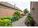 Well-maintained side yard with lush greenery and a concrete walkway at 131 Olde Mill Bay, Indianapolis, IN 46260