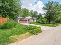 Beautiful house boasting a lush green lawn and colorful flowers surrounding the landscaped yard and the house at 1325 Countryside Ln, Indianapolis, IN 46231