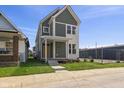Charming two-story home featuring a welcoming porch, a well-manicured lawn, and fresh flowers at 1405 Deloss St, Indianapolis, IN 46201