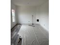 Room with new flooring being installed, plastic-covered floors, and bright walls at 1441 Elm St, Martinsville, IN 46151