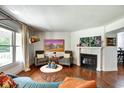 Sunlit living room featuring hardwood floors, a fireplace, and large windows for natural light at 1548 N Park Ave, Indianapolis, IN 46202
