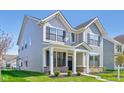 Attractive two-story home featuring a covered front porch, manicured landscaping, and complementary exterior colors at 1694 Windrush Pl, Westfield, IN 46074