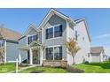 Well-maintained two-story home with a classic design, complemented by a green lawn and young trees at 1694 Windrush Pl, Westfield, IN 46074