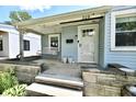 Inviting front porch features a swing, stone accents, and a white front door, offering a cozy entrance at 209 E John St, Alexandria, IN 46001