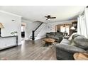 Spacious living room with hardwood floors, grey sofas, a staircase, and an archway leading to the dining room at 209 E John St, Alexandria, IN 46001