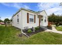 A cozy bungalow with lovely landscaping and unique window shutters at 2164 E Raymond St, Indianapolis, IN 46203