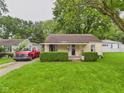 Traditional home with a cozy front porch, neat landscaping, and gravel driveway at 2405 E 9Th St, Anderson, IN 46012