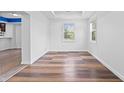 Bright living room with hardwood floors, fresh white paint, and large windows offering views of the landscaped outdoors at 541 Dayton Ave, Indianapolis, IN 46203
