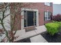 Elegant front door with sidelights, framed by brick and lush landscaping at 5883 Sandalwood Dr, Carmel, IN 46033