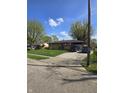 Lovely home exterior with a lush green lawn, driveway, and mature trees on a sunny day at 6133 Ashway Ct, Indianapolis, IN 46224
