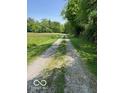 Gravel driveway leading through picturesque greenery, offering a sense of seclusion at 622 S Washington St, Morristown, IN 46161