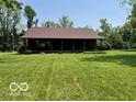 Charming cabin with a full-length front porch, nestled in a tranquil, grassy setting at 622 S Washington St, Morristown, IN 46161