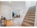 Bright entryway featuring hardwood floors, a staircase, and a view of the living room at 6507 W Whispering Way, Greenfield, IN 46140