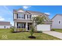 Charming two-story home with a well-manicured lawn and a two-car garage at 6507 W Whispering Way, Greenfield, IN 46140